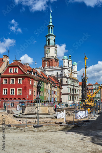 Historic tenement houses, historic town hall tower and construction machinery on the market square in Poznan