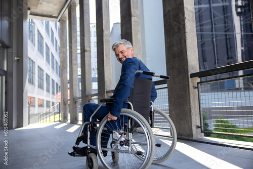Fototapeta Naklejka Na Ścianę i Meble -  Gray haired disabled man wearing official style suit in wheelchair city background.