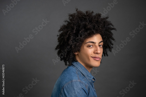Curly-haired young guy smirking and looking foxy