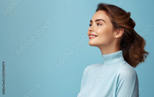 Dreamy and pensive looking young woman in profile portrait - isolated on light blue background