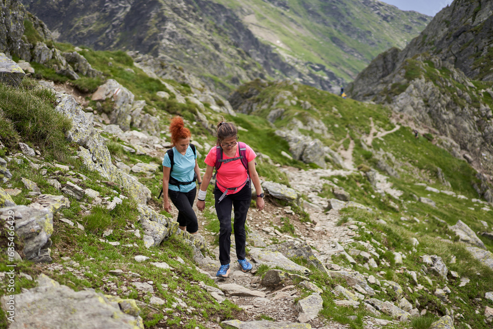 Women hiking on a trail in the rocky mountains