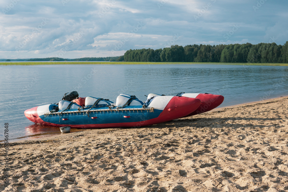 Fototapeta premium inflatable raft-catamaran for whitewater sports is moored on the river bank