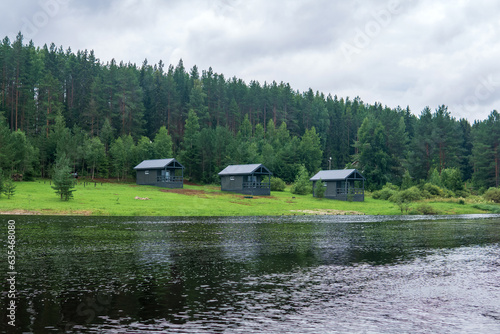 Obraz na plátně river landscape with cottages on a wooded bank