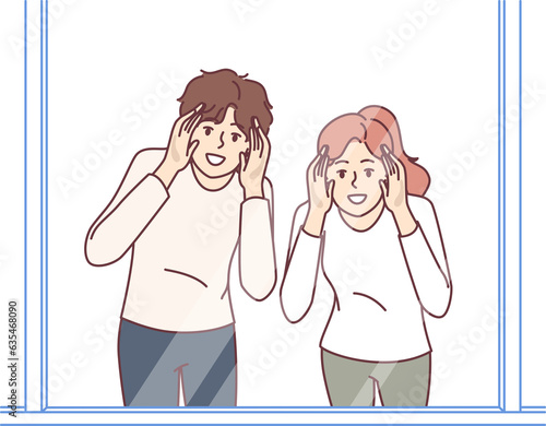 Man and woman look through glass showcase to examine product they like or follow customers of store