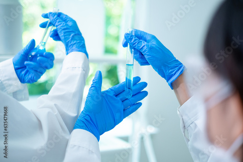 Close up of two scientists compare substances or liquid in laboratory. Concept of analysis team work, Discussion of the result of experiment. Biotechnology and chemical discovery. Innovation research.