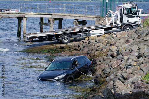 Fotografie Car submerged in water due to incoming tide on the River Clyde