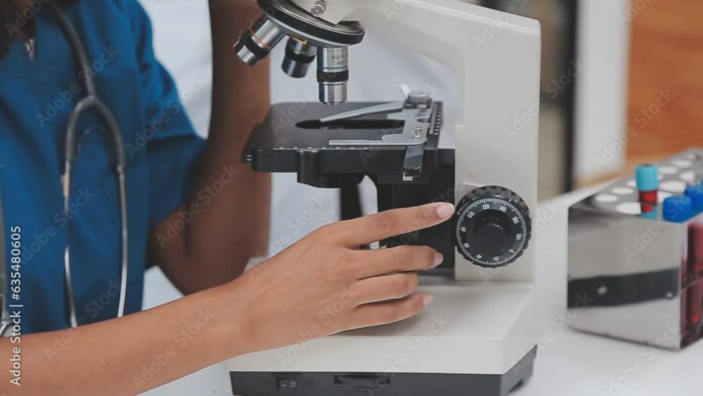 Health care researchers working in life science laboratory. Young female research scientist and senior male supervisor preparing and analyzing microscope slides in research lab. Health care researchers working in life science laboratory. Young female research scientist and senior male supervisor preparing and analyzing microscope slides in research lab.