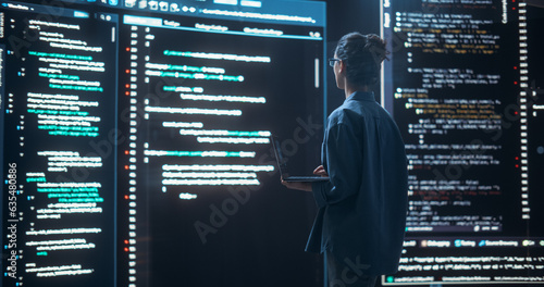 Shot of Female Programmer Working in a Monitoring Control Room, Surrounded by Big Screens Displaying Lines of Programming Language Code. Portrait of Woman Creating a Software, Coding