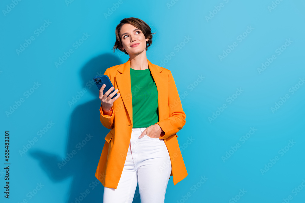 Photo of young thoughtful girl formal blazer dream phone look novelty download app for calculating money isolated on blue color background Photo of young thoughtful girl formal blazer dream phone look novelty download app for calculating money isolated on blue color background