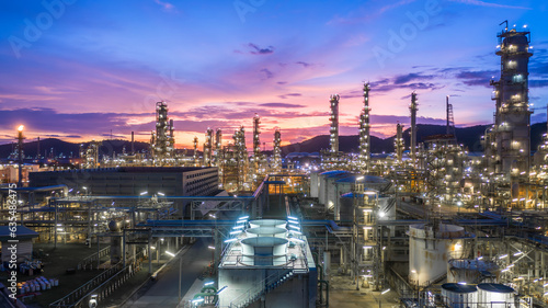 Aerial view oil and gas tank with oil refinery background at night, Glitter lighting of petrochemical plant with night, Manufacturing of petroleum, Products tank in petrochemical plant.