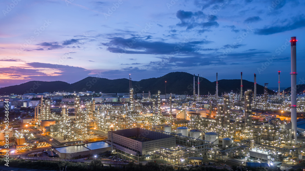 Obraz premium Aerial view oil and gas tank with oil refinery background at night, Glitter lighting of petrochemical plant with night, Manufacturing of petroleum, Products tank in petrochemical plant.