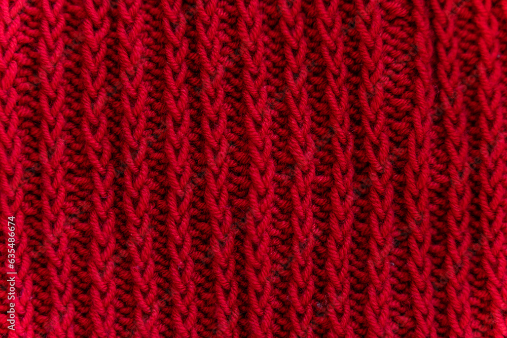 Knitted texture of weaving from red dense threads of wool