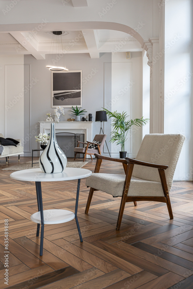 Fototapeta premium a chic expensive bright interior of a huge living room in a historic mansion with arched arches, columns and white walls decorated with ornaments and stucco.
