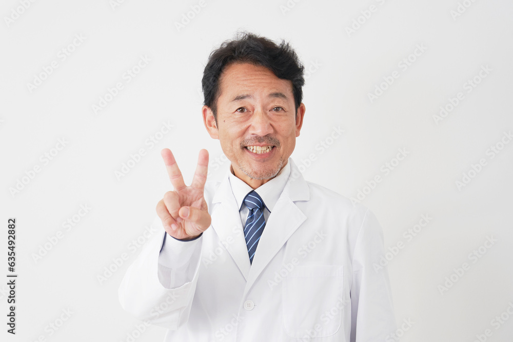 ピースサインをするミドルエイジの医者　白背景