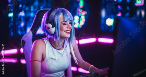 Portrait of a Stylish Streamer and Video Gamer with Blue Hair Chats with Internet Fans on Computer in Futuristic Cyber Technology Room. Footage for Social Media, Streaming, and Gaming Content © Gorodenkoff