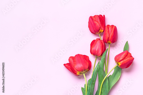 Fototapeta Naklejka Na Ścianę i Meble -  Bouquet of red tulips on pink background Top view Flat lay Holiday greeting card Happy moter's day, 8 March, Valentine's day, Easter concept Copy space Mock up