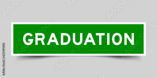 Green color square shape sticker label with word graduation on gray background