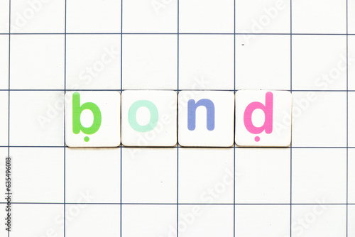 Colorful tile letter in word bond on white grid background photo