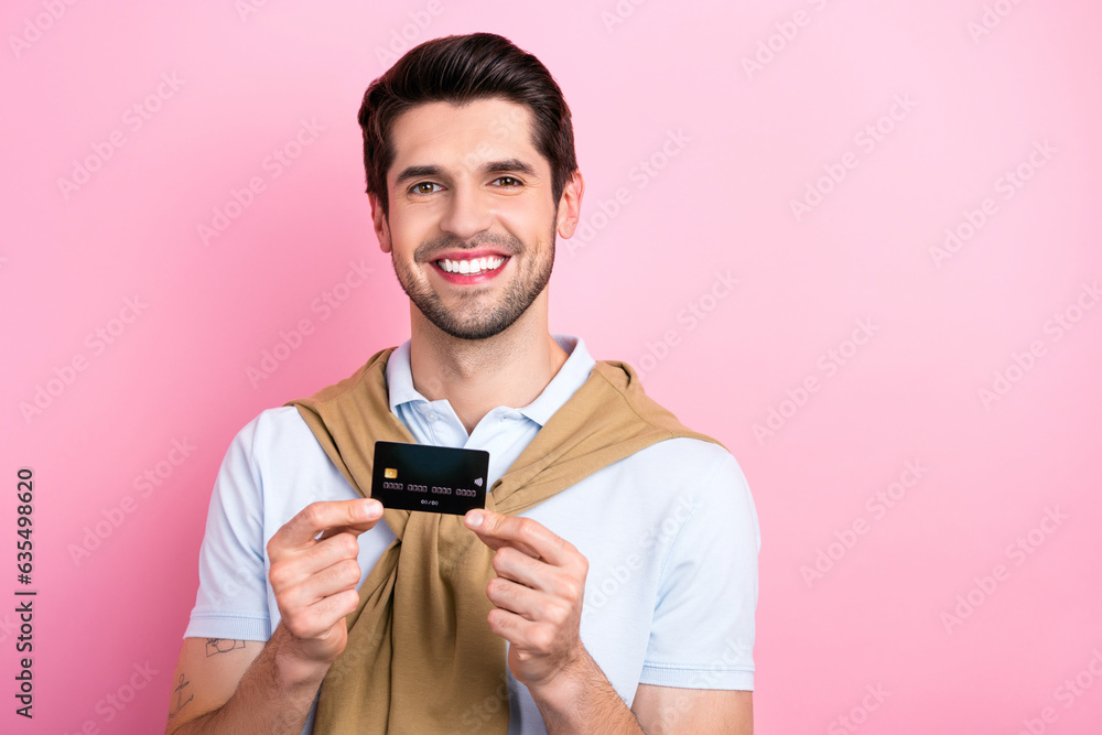Photo of friendly positive man wear trendy clothes showing recommending plastic debit card empty space isolated on pink color background Photo of friendly positive man wear trendy clothes showing recommending plastic debit card empty space isolated on pink color background
