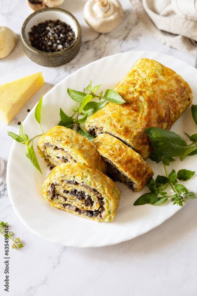 Vegetarian delicious food. Zucchini roll (roulade) with cheese and mushrooms on a marble tabletop. Copy space. Vegetarian delicious food. Zucchini roll (roulade) with cheese and mushrooms on a marble tabletop. Copy space.