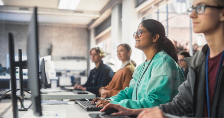 Portrait of a South Asian Female Student Studying in College with Diverse Classmates. Indian Girl Listening to Teacher, Using Computer to Apply Her Knowledge to Acquire New IT Skills in Class