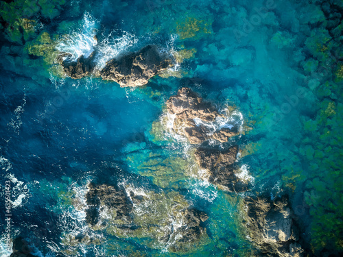 Vista aérea de olas con rocas en agua turquesa