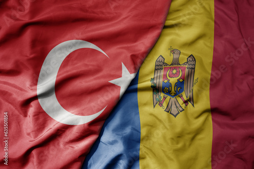 big waving national colorful flag of turkey and national flag of moldova .