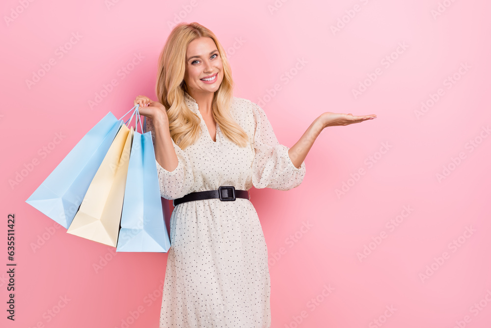 Photo of young beautiful pretty woman blonde curly hair hold arm empty space brand name promo bargains isolated on pink color background Photo of young beautiful pretty woman blonde curly hair hold arm empty space brand name promo bargains isolated on pink color background