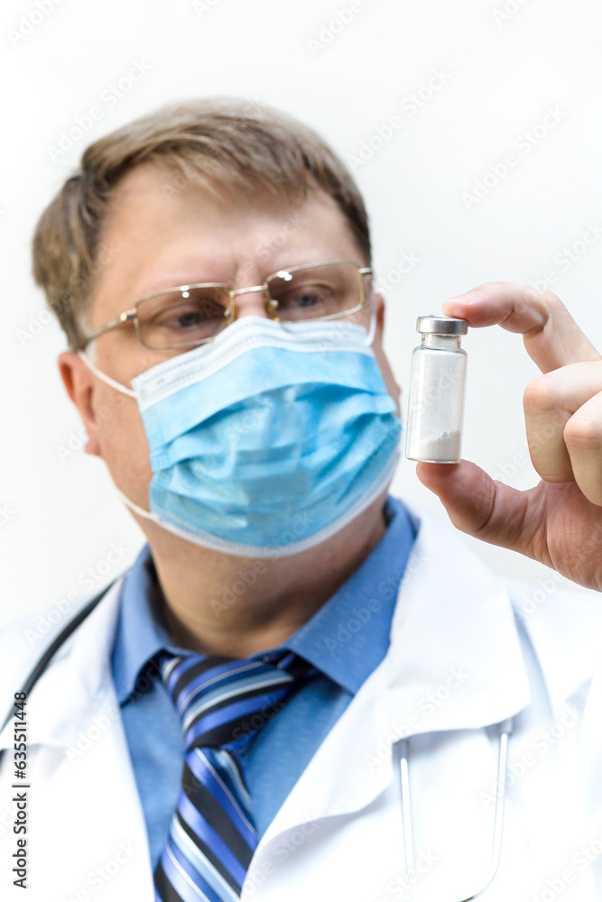 A doctor in a mask carefully looks at tests in test tube, concept of biotechnology. A doctor in a mask carefully looks at tests in test tube, concept of biotechnology.