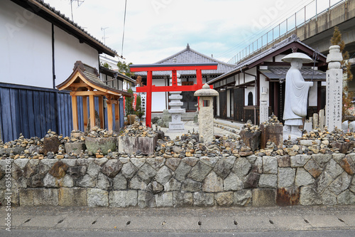 Japaness architecture in town, a beautiful cluture with historic. The shinto shrine with carved stone statue and red torii. Kyoto, Japan. photo