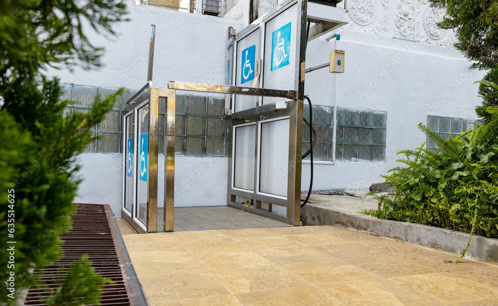 View of Accessible Elevator with sign. Disabled persons lift near modern ...