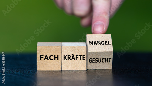 Photo Hand dreht Würfel und ändert den Ausdruck 'Fachkräfte gesucht' in 'Fachkräftemangel'
