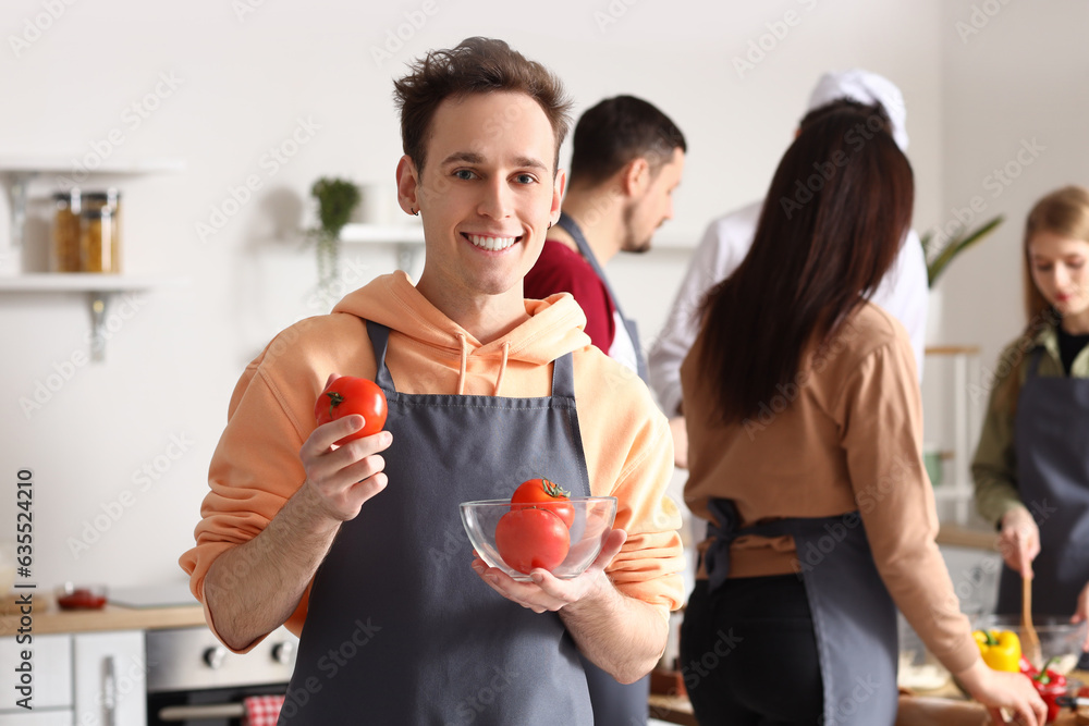 Young man with bowl of tomatoes during cooking class in kitchen Stock ...