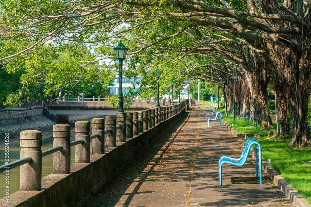 Empty footpath along river in Guangzhou. There are trees and some benches to take a seat. Empty footpath along river in Guangzhou. There are trees and some benches to take a seat.