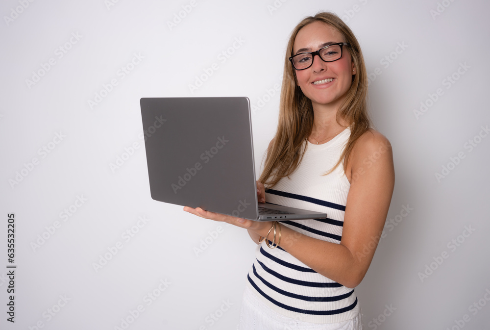 Image of cheerful young woman standing isolated over white background using laptop computer. Looking at camera. Image of cheerful young woman standing isolated over white background using laptop computer. Looking at camera.