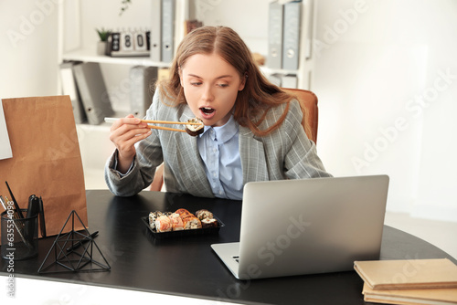 Young businesswoman eating ...