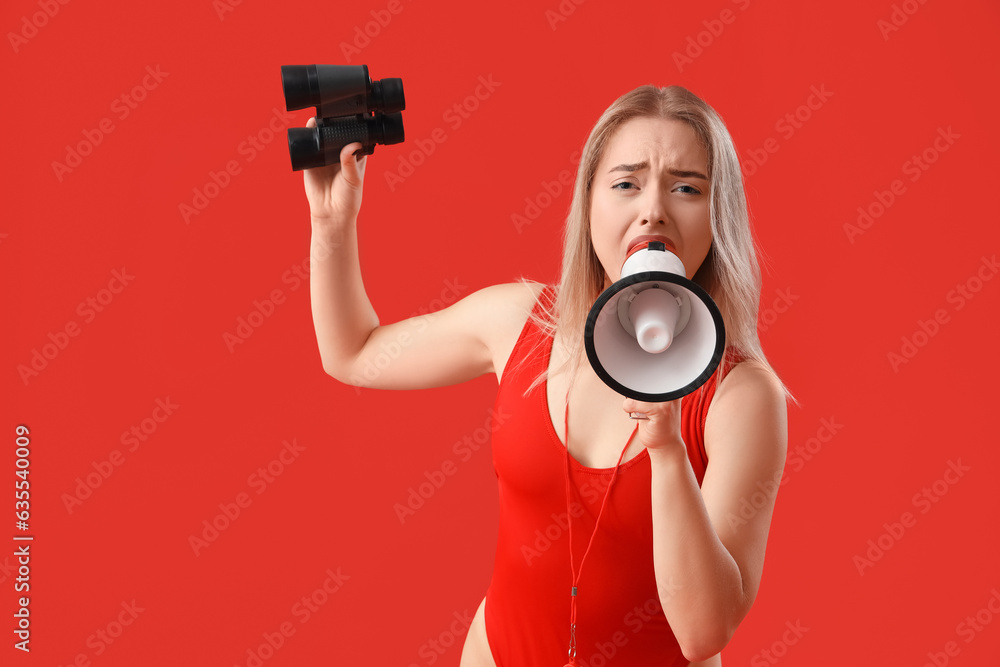 Obraz premium Female lifeguard with binoculars shouting into megaphone on red background