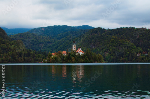Sunset landscape view of small island with Pilgrimage Church of the Assumption of Maria on Bled Lake. Church reflection in water. The most famous lake in Slovenia. Concept of landscape and nature photo
