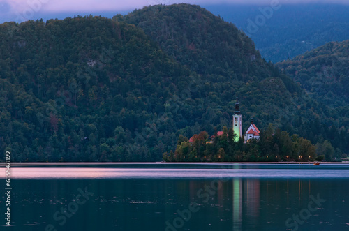 Small island with Pilgrimage Church of the Assumption of Maria on Bled Lake. Church reflection in water. The most famous lake in Slovenia. Blue hour. Travel and tourism concept photo