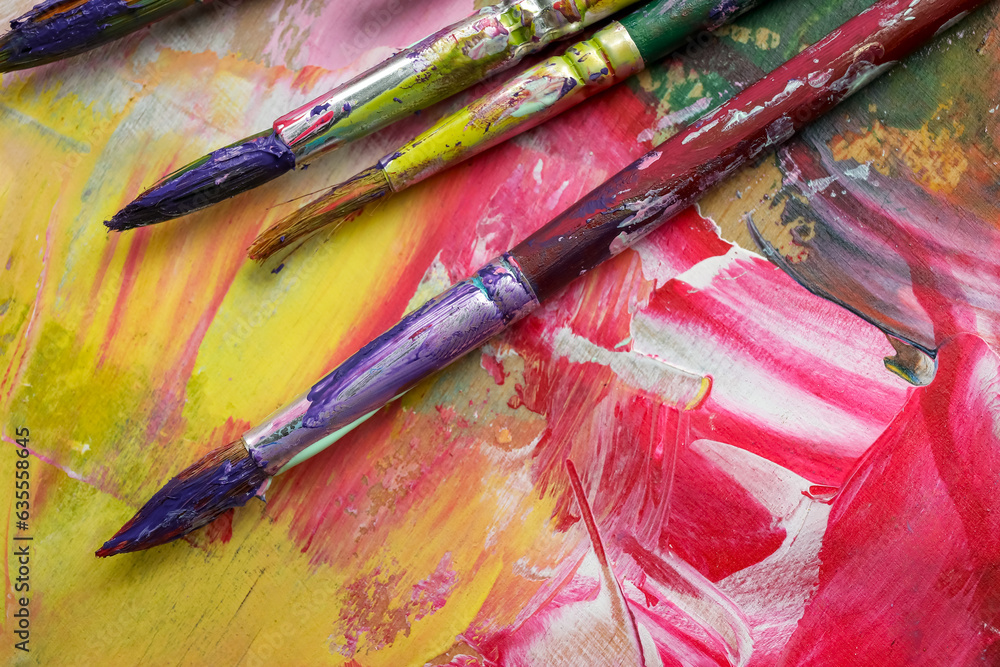 Obraz premium Dirty paint brushes on colorful background