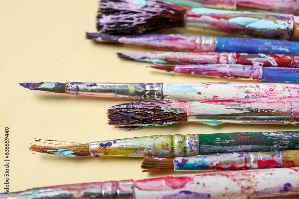 Obraz premium Dirty paint brushes on beige background