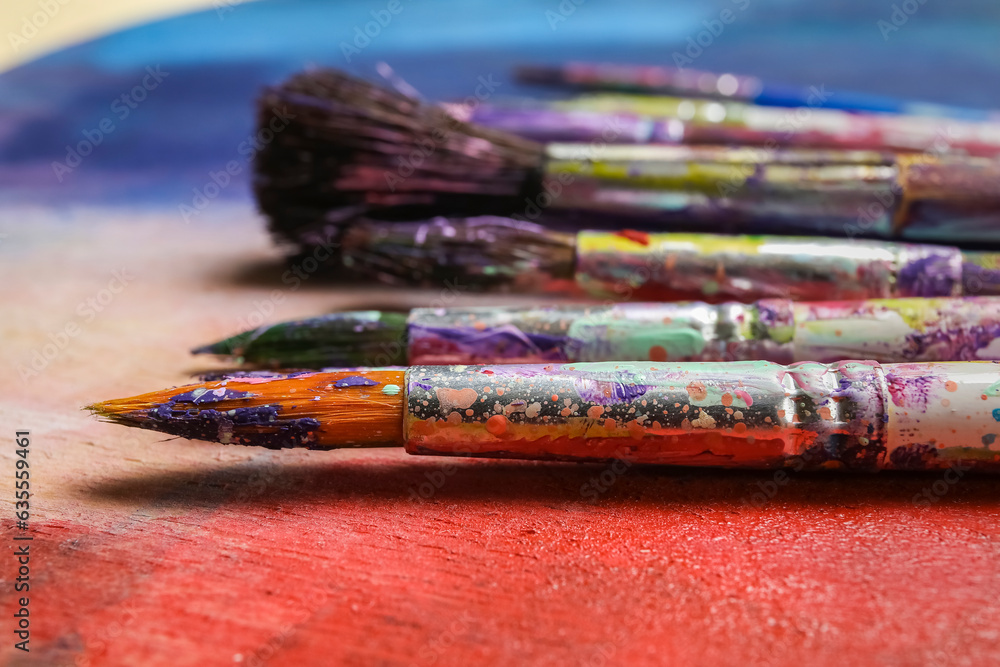 Fototapeta premium Dirty paint brushes on colorful background