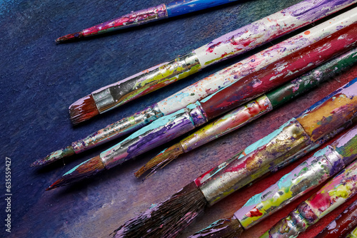 Dirty paint brushes on colorful background
