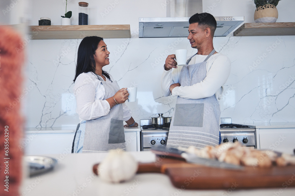 Fototapeta premium Couple in kitchen, coffee and cooking together with conversation, smile and love in home. Relax, man and woman in bonding discussion, making food for dinner vegetables and drinking tea in apartment.