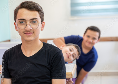 school kids standing behinde each other while smiling