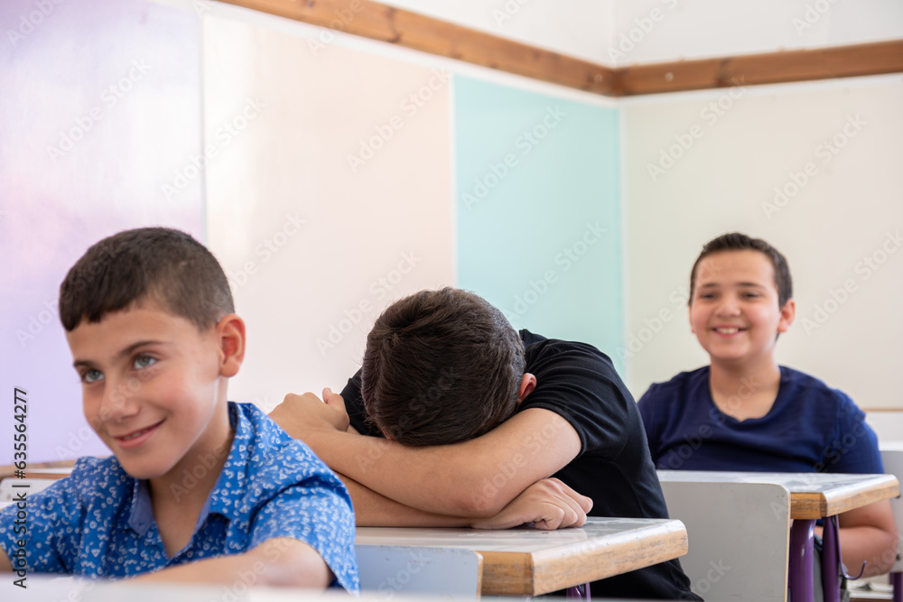 Student putting his head on the desk ,looks not feeling well or sleeping Student putting his head on the desk ,looks not feeling well or sleeping