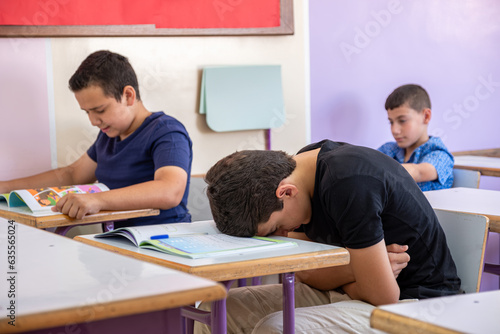 Student putting his head on the desk ,looks not feeling well or sleeping
