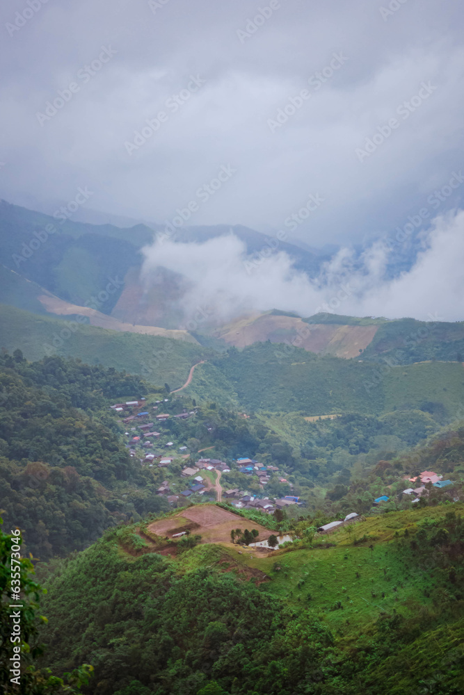 The stunning view from a tourist's standpoint as they go down a hill on a foggy trail in Nan, Thailand.