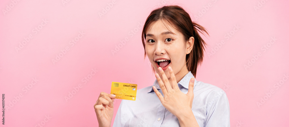 © Katcha - Young asian woman holding credit card and raising one hand to covering mouth while feeling surprised