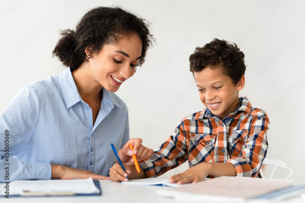 Teacher Woman Teaching School Kid Boy Sitting At Desk Indoors Teacher Woman Teaching School Kid Boy Sitting At Desk Indoors